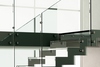 Scala con fascioni laterali a Z inox – ringhiera, pedate e balaustra in vetro.
